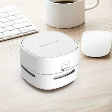 White Mini Vacuum Cleaner For Table Compact 360° Desk Cleaning Solution on a desk with a keyboard, mug, and mouse in the background