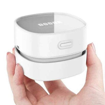 White Mini Vacuum Cleaner For Table Compact 360° Desk Cleaning Solution held in a hand with a clear lid on a white background