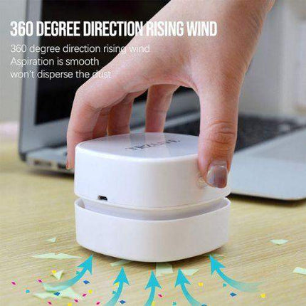 Hand holding a white Mini Vacuum Cleaner For Table Compact 360° Desk Cleaning Solution with text about its features, set against a blurred office background.