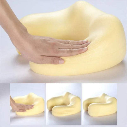 Yellow U-Shaped Neck Massager Pillow with a hand touching it on a light gray background