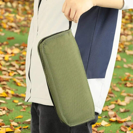 Foldable Backpack Stool portable carrying bag for outdoor adventures, secured in hand against a backdrop of autumn leaves.