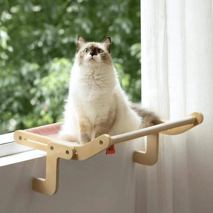 Cat sitting on a window perch Sturdy Hanging Cat Bed with a blurred green outdoor background