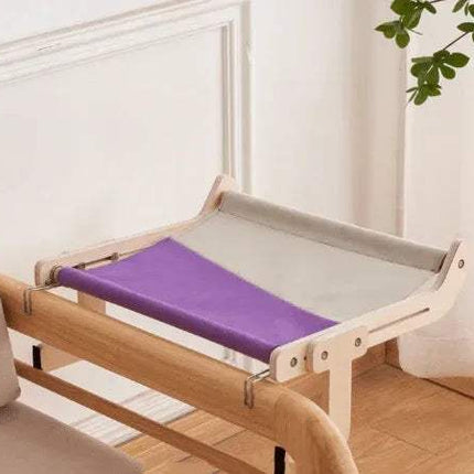 Sturdy Hanging Cat Bed with purple and gray cushion on a wooden floor.