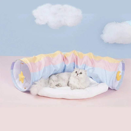 Cat lying on a colorful Pet Cats Tunnel Toy with a cloud-themed background