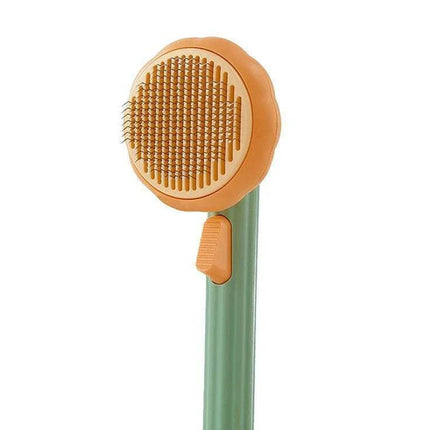 Pet Brush Comb Self-Cleaning Grooming Tool with orange bristle head and green handle on a white background