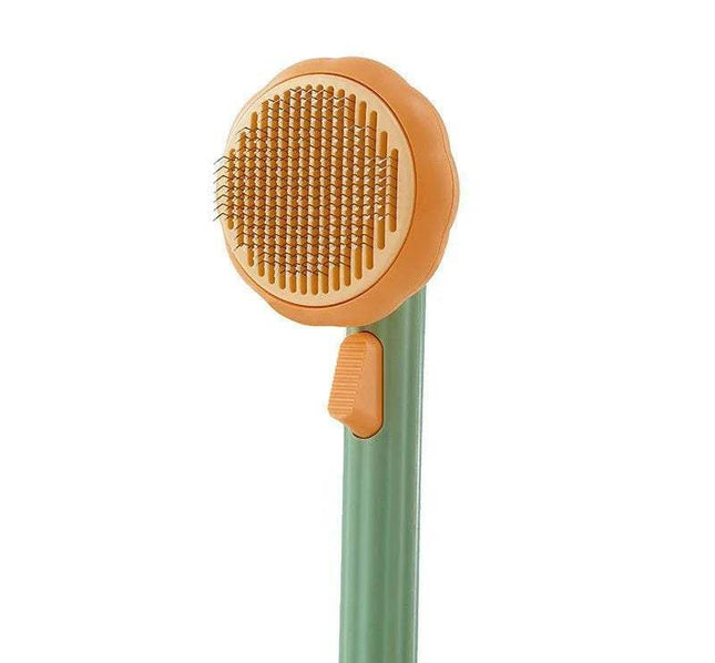 Pet Brush Comb Self-Cleaning Grooming Tool with orange bristle head and green handle on a white background