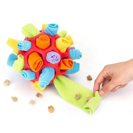 Colorful Pet Snuffling Ball Toy with a hand interacting with it on a white background