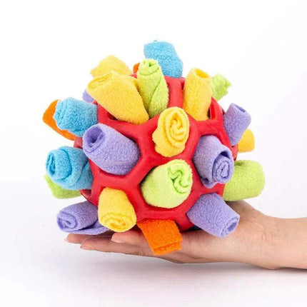 Colorful Pet Snuffling Ball Toy held in a hand on a white background