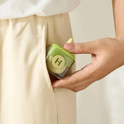 Hand holding a Portable Fur Remover, inserting it into a beige pocket.