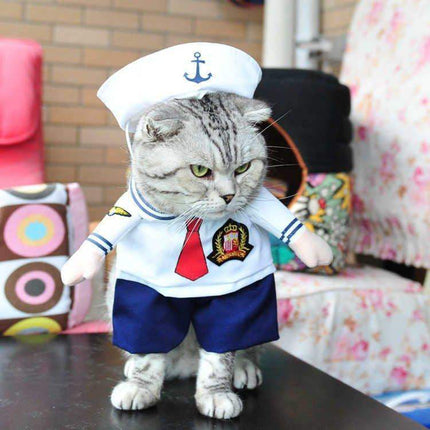 Cat wearing a sailor Funny Pet Costumes with a hat and tie on a table.
