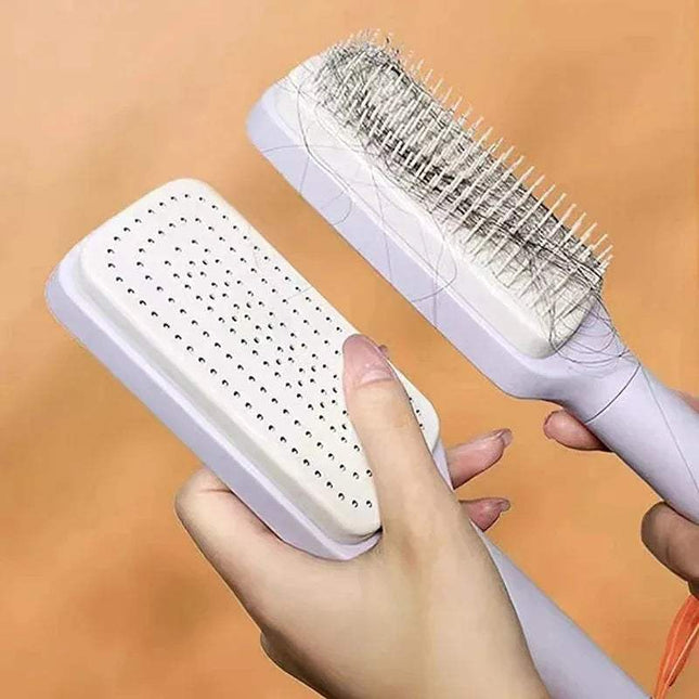 White Self-Cleaning Hairbrush Hassle-Free Grooming & Smooth Styling with bristle head held by a hand against an orange background