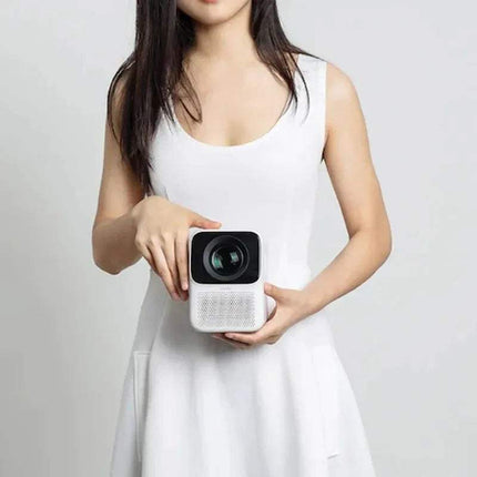 Person holding a white WANBO T2 Max Projector 1080P against a plain background