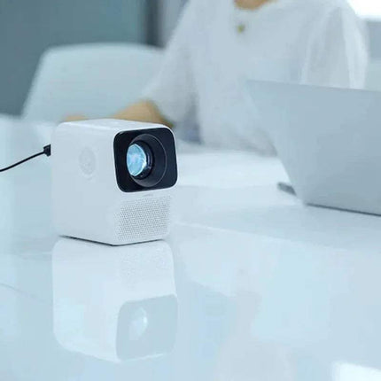 WANBO T2 Max Projector 1080P on a white surface with a blurred background
