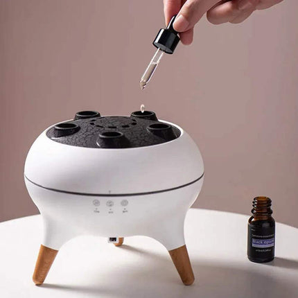 Hand adding essential oil to a Jellyfish Diffuser & Humidifier for relaxation and aromatherapy.