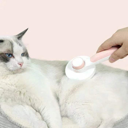 Person using a Self-Cleaning Pet Brush Gentle Grooming & Undercoat Removal on a cat with a pink background