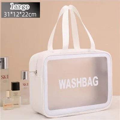 White Portable Transparent Waterproof Travel Wash & Makeup Bag with transparent front panel on a beige background