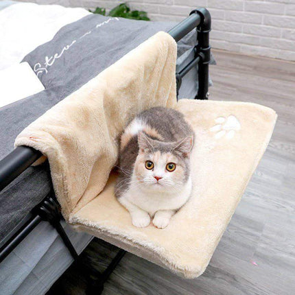 Cat sitting on a Cat Hanging Bed Plush Orthopedic Perch attached to a bed