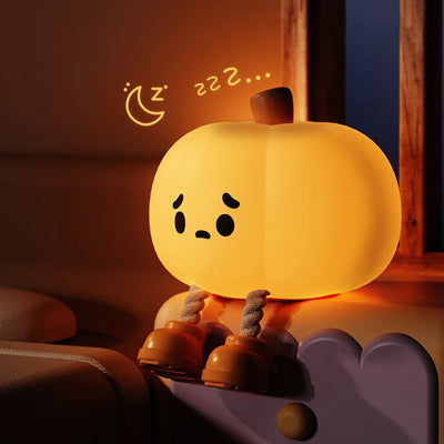 Cute Pumpkin Night Light with a sleeping expression on a soft surface.