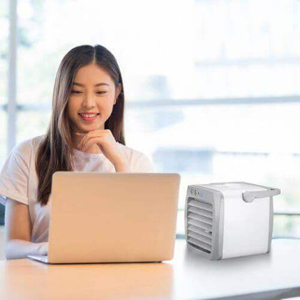 Mini Air Conditioner with Woman using a laptop on a desk in a bright room.