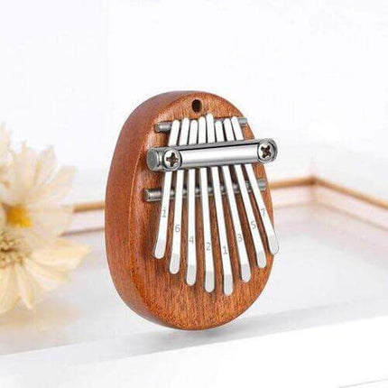 Mini Kalimba Thumb Piano with metal tines on a white background