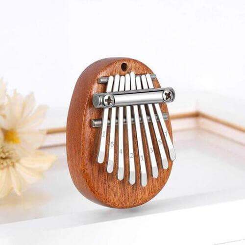 Mini Kalimba Thumb Piano with metal tines on a white background