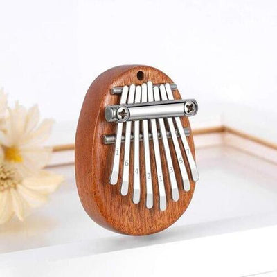 Mini Kalimba Thumb Piano with metal tines on a white background