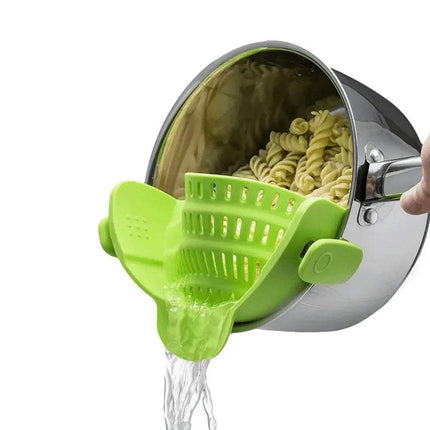 Green Universal Silicone Strainer Clip being used to drain pasta from a pot on a white background