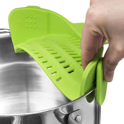 Green Universal Silicone Strainer Clip being used on a pot