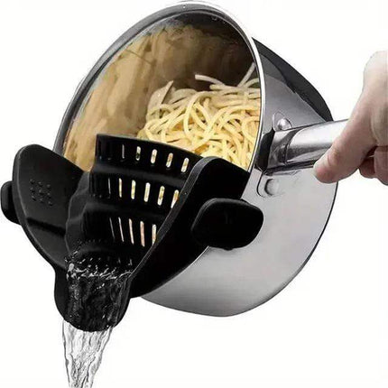 Pasta being drained from a pot with a black Universal Silicone Strainer Clip.